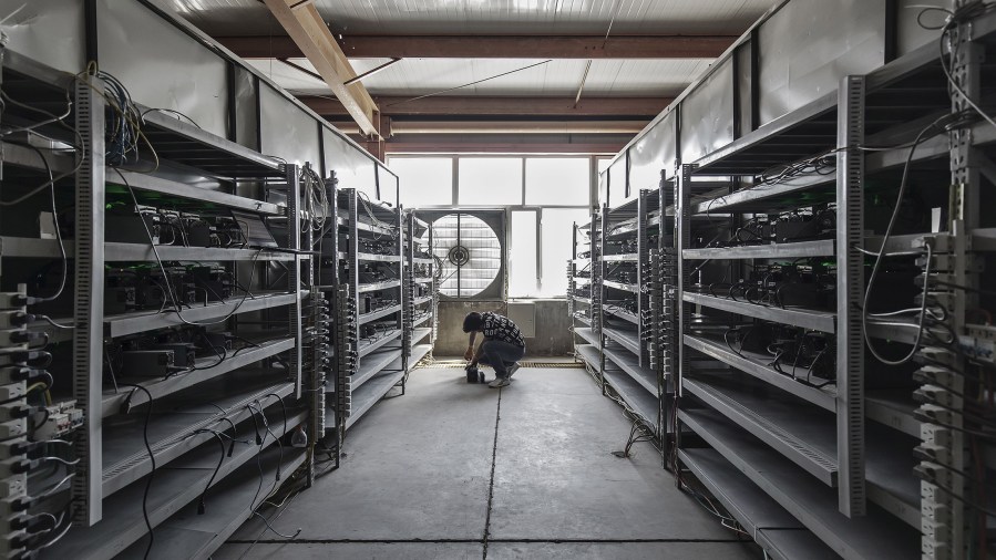 Technician inspects Bitcoin Mining machines.jpg
